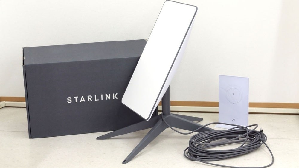 Starlink satellite dish with its box and equipment placed indoors.