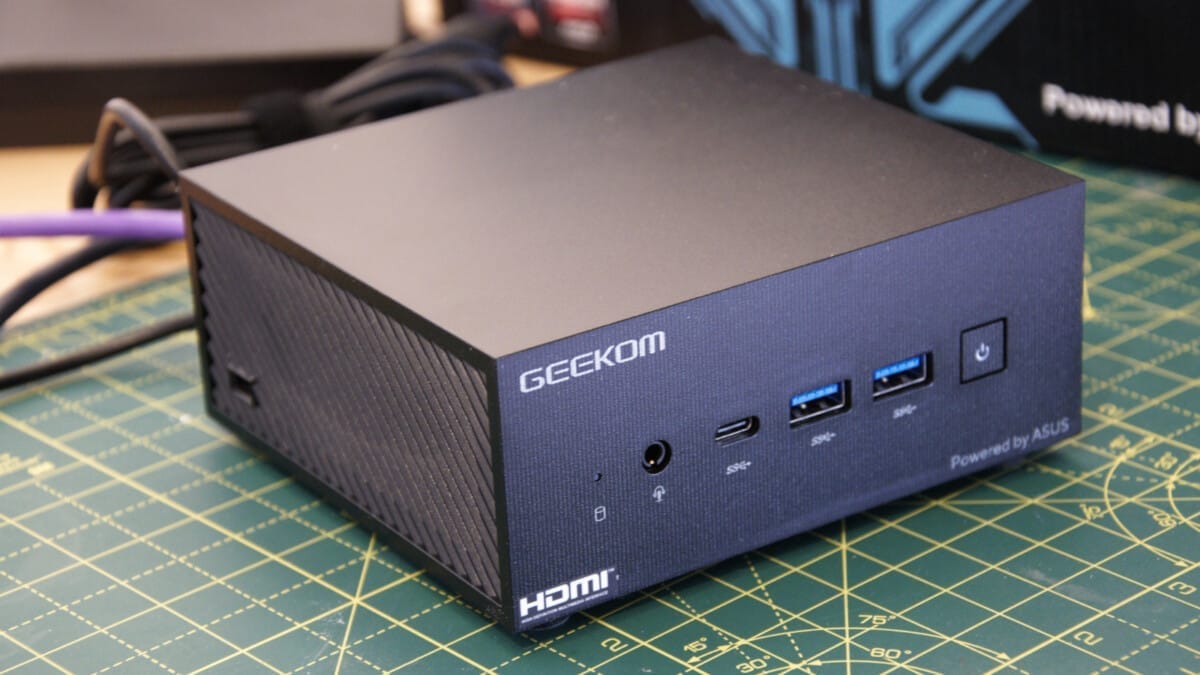 GEEKOM mini PC with various ports and logos.