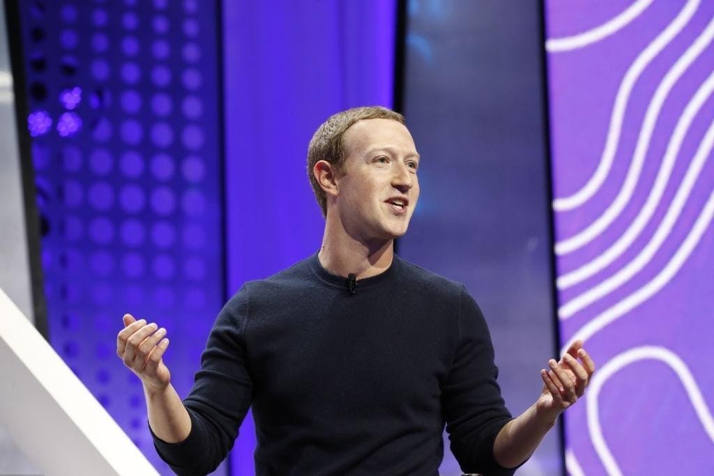 Image of Mark Zuckerberg presenting on stage with a modern background and vibrant lighting.