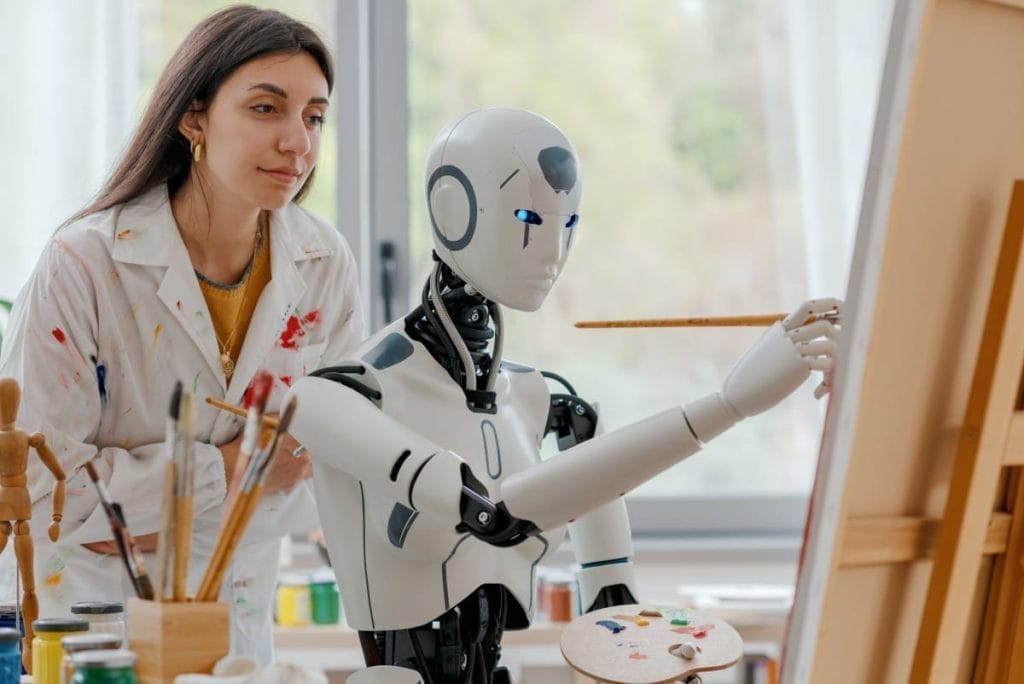 A woman observing a robot painting a picture, showing human-technology collaboration in art