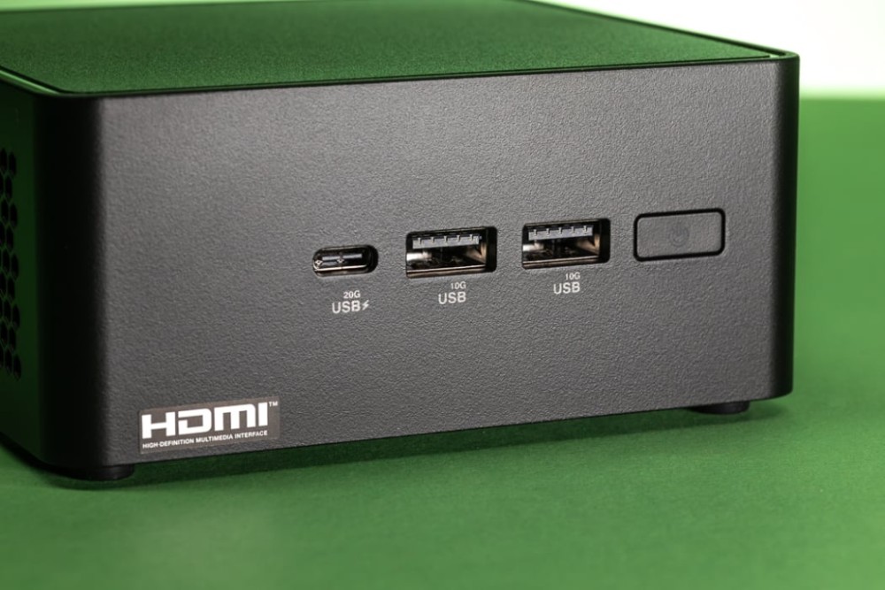 A close-up view of a sleek black device showcasing HDMI and USB ports on a green background.