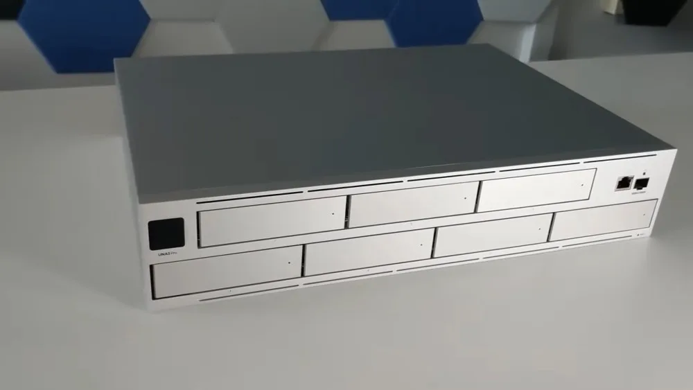 A sleek NAS server unit on a table, featuring multiple drive bays and ports.