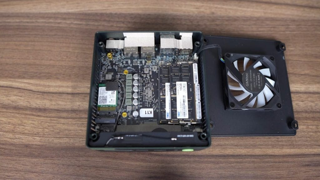 An image of the internal components of the GMKtec K11 compact computer, featuring a heatsink and fan, highlighting the details of the motherboard and memory modules.