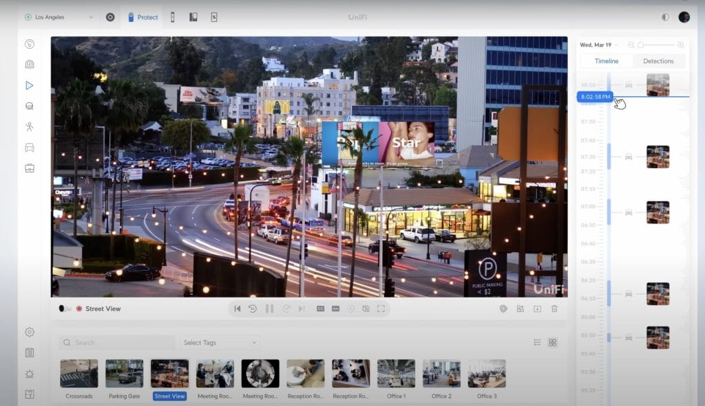 A bustling street view of Los Angeles with traffic, palm trees, and illuminated billboards highlighting a vibrant urban landscape.