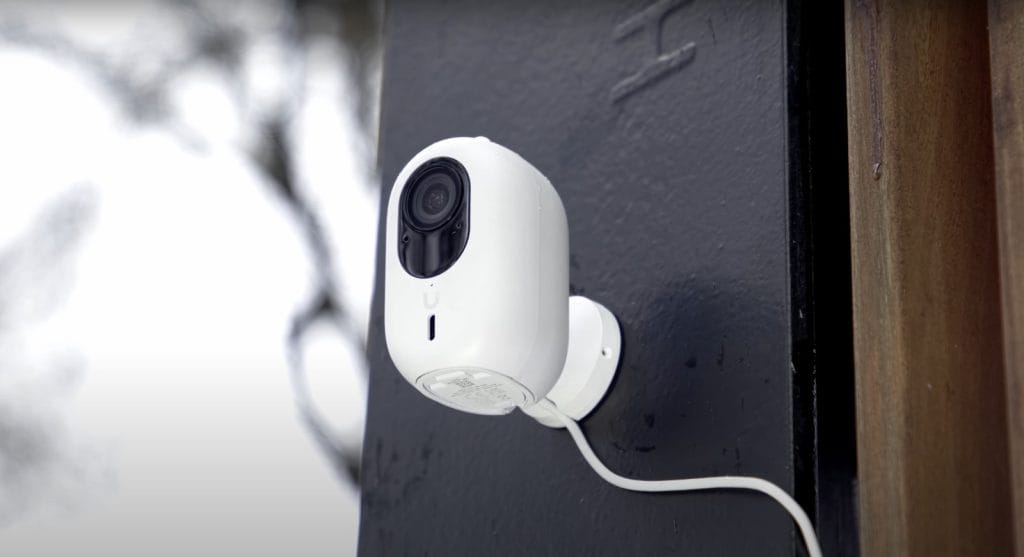 A smart outdoor security camera mounted on a wall, capturing the surrounding area.