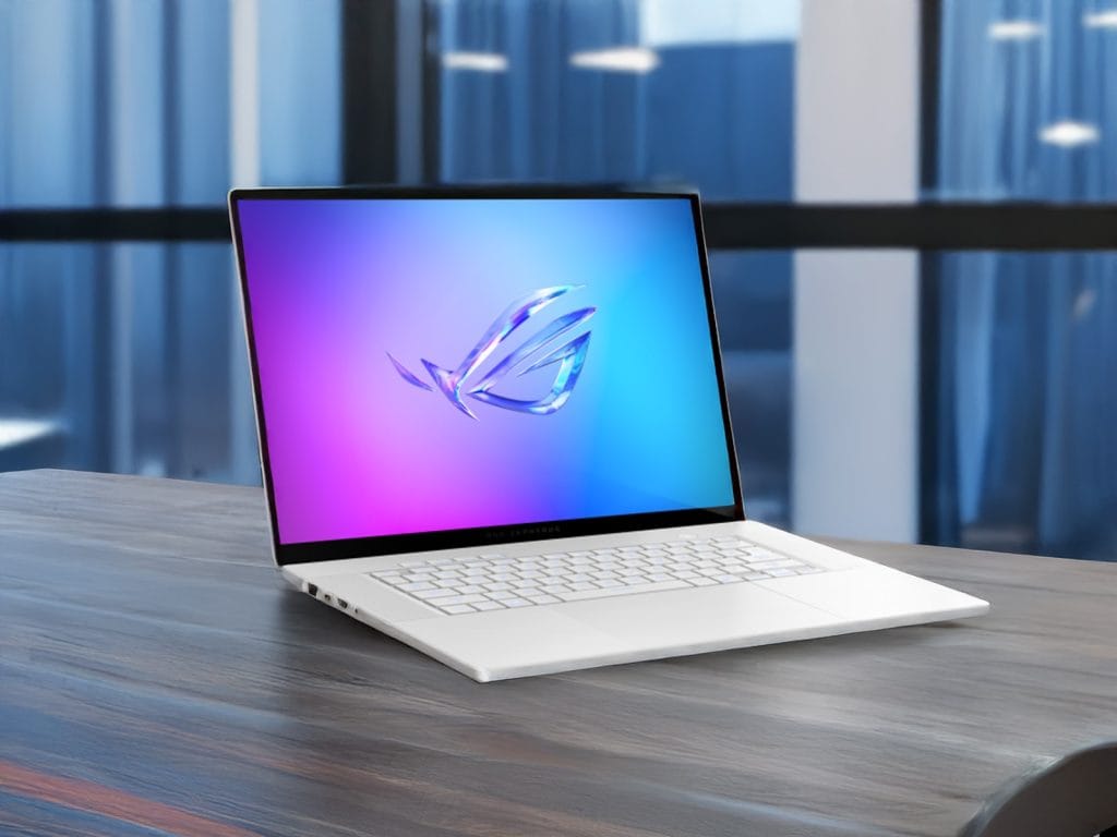 ASUS Zephyrus G16 . A sleek laptop sitting on a wooden desk with a vibrant screen display featuring the ROG logo