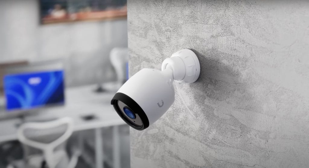 A modern security camera mounted on a textured wall, ideal for surveillance and monitoring.