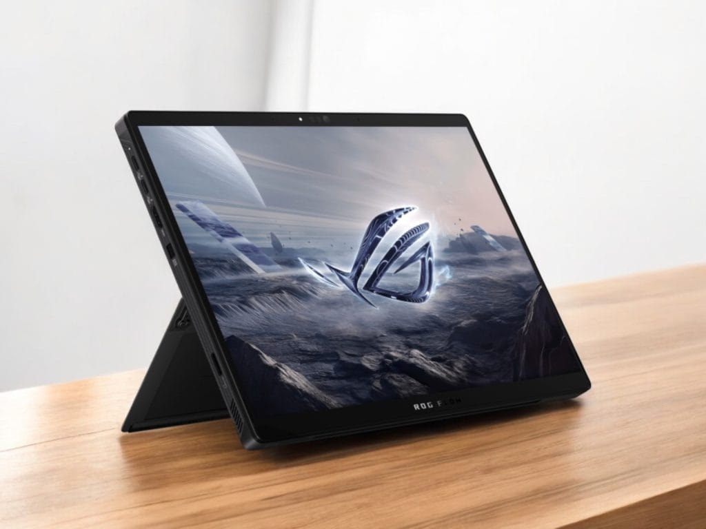 Asus Flow Z13 2025. A sleek Asus ROG Flow laptop displaying an alien landscape wallpaper on a wooden table.