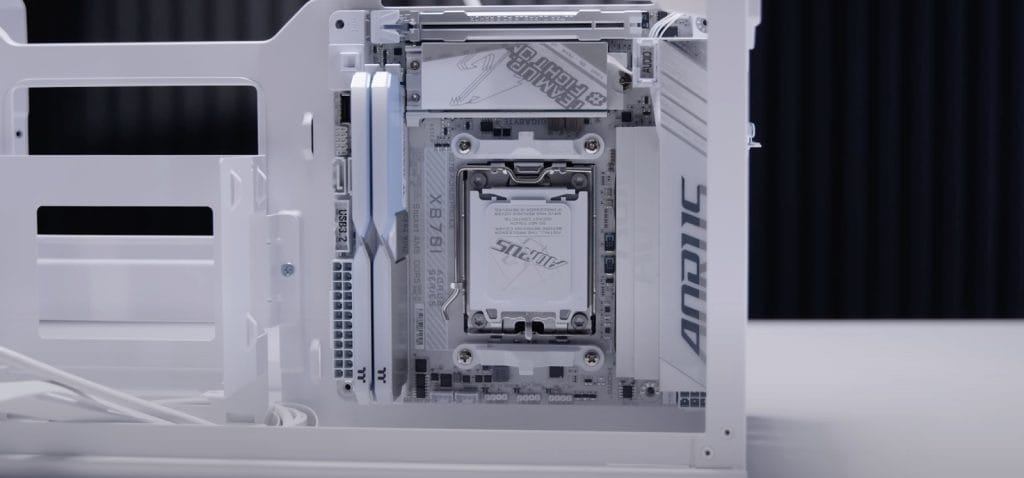 Thermaltake TR100 SFF A close-up view of a white computer motherboard with a mounted CPU and RAM, showcasing a modern build.