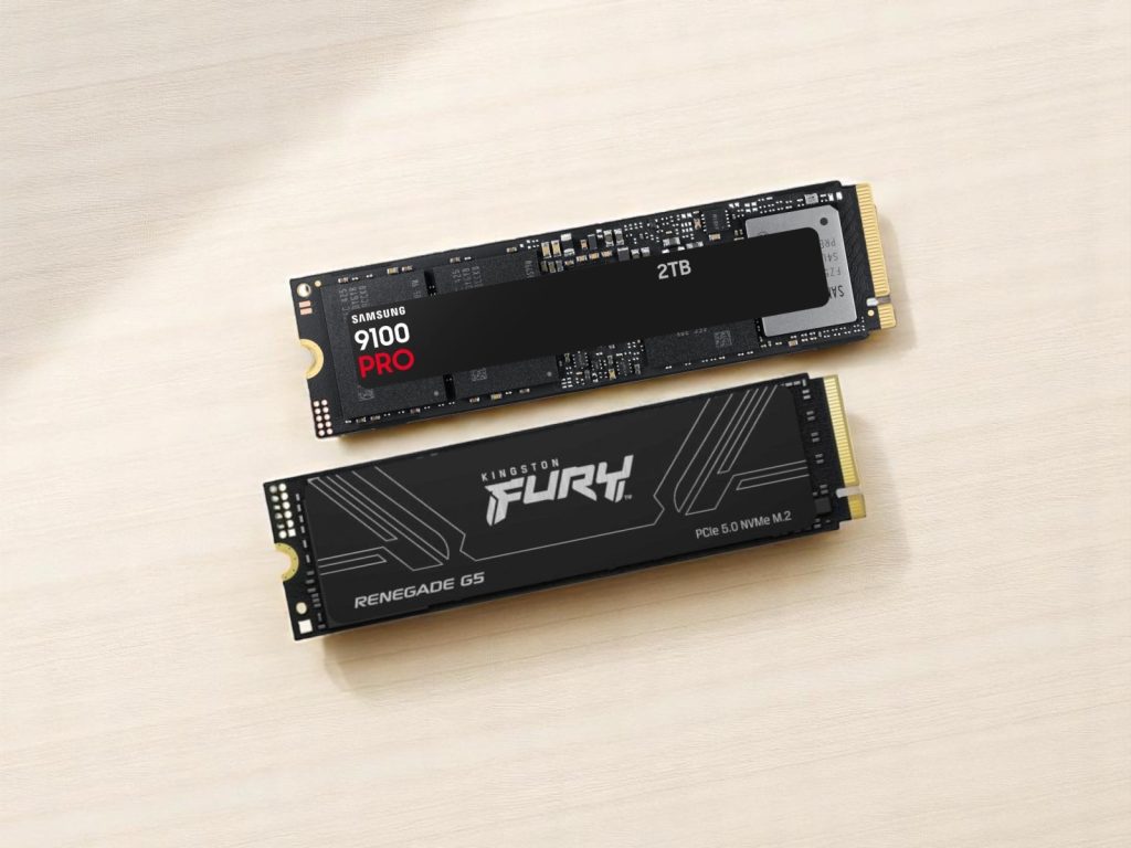 Two M.2 NVMe SSDs on a light wooden surface, featuring a Samsung 9100 PRO 2TB and a Kingston Fury Renegade G5 PCIe 5.0 NVMe drive