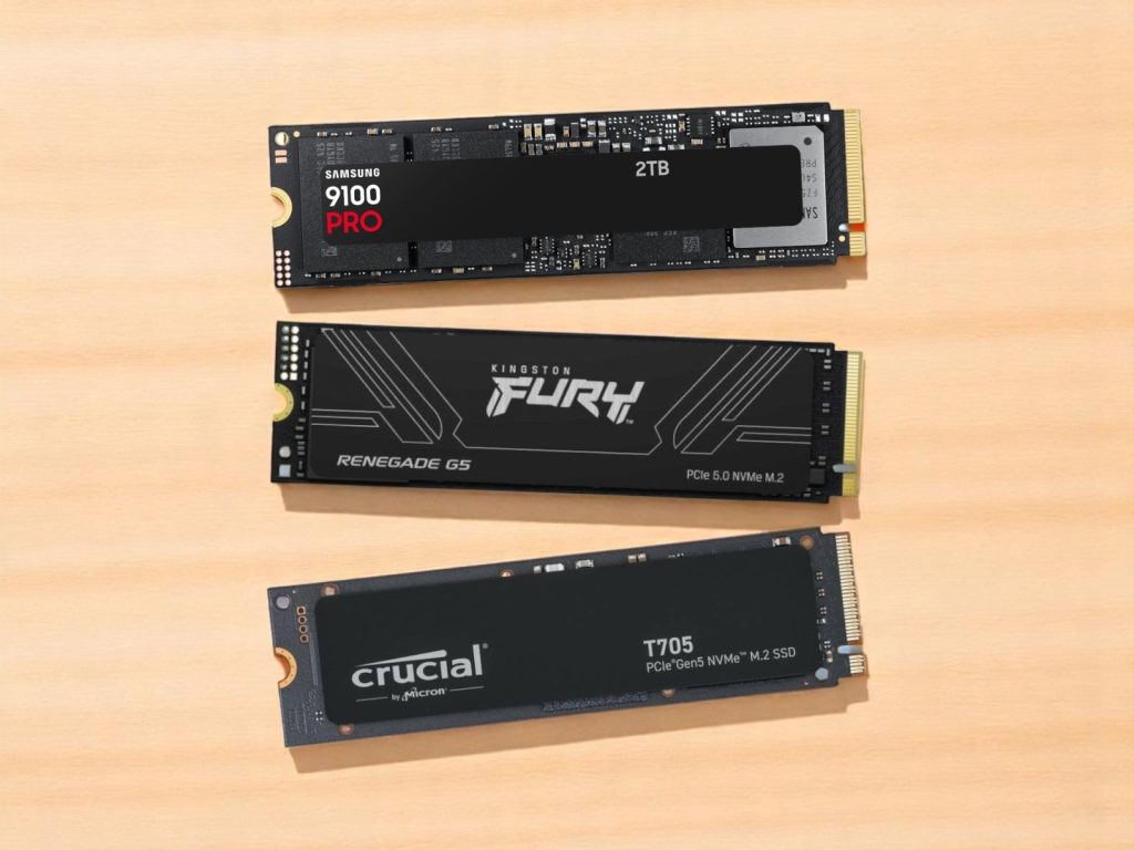 Three high-performance NVMe M.2 solid state drives from Samsung, Kingston, and Crucial placed on a wooden surface