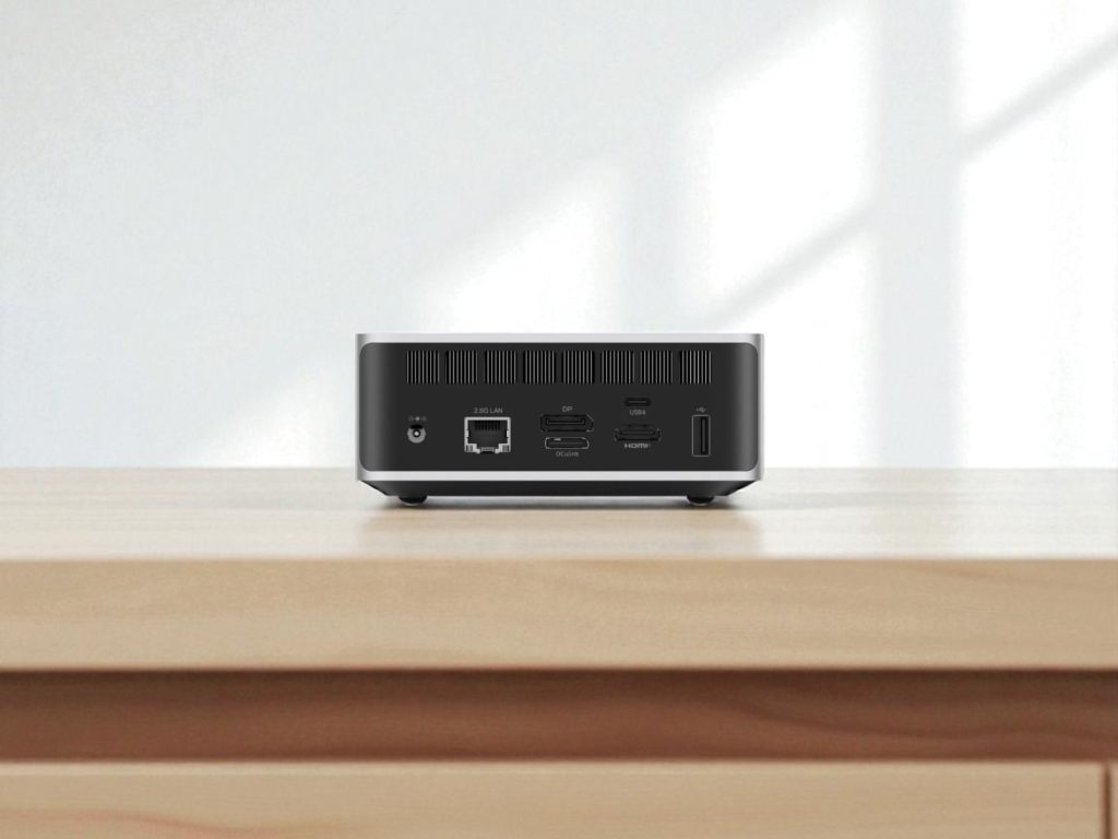 Minisforum AI X1 Mini PC. Back view of a modern mini PC on a wooden desk featuring multiple ports including 2.5G LAN, USB4, HDMI, DP, and power connector